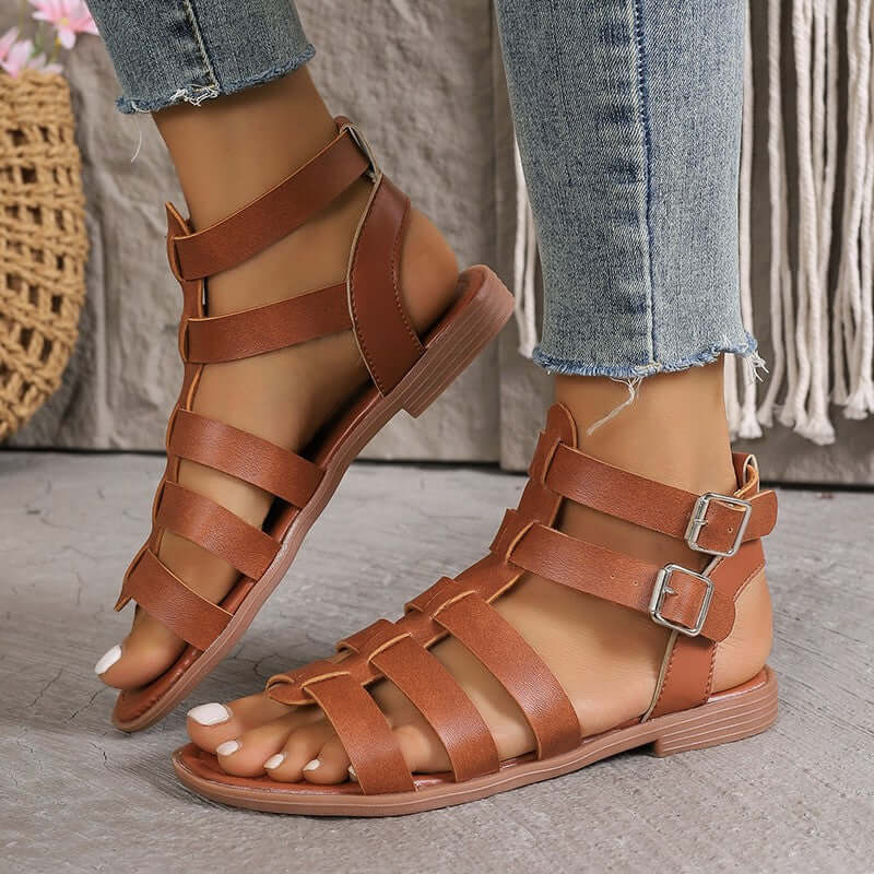 Sandales plates femme en similicuir beige style romain avec boucles réglables et bout ouvert, vue de face.