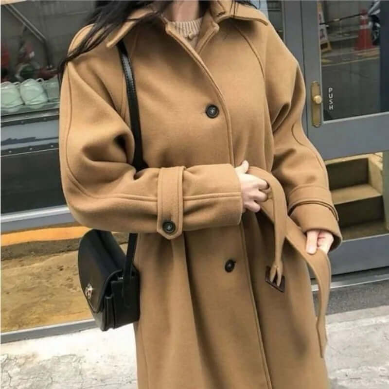 Manteau long femme élégant, silhouette ajustée, couleur sombre, idéal pour hiver, allie style et chaleur, look intemporel.