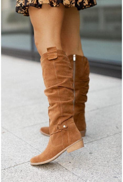 "Bottes femme en daim élégant, coupe ample, lanières et boucles décoratives, style automne-hiver."