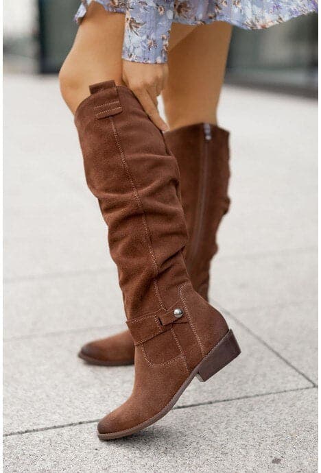 "Bottes femme en daim élégant, coupe ample, lanières et boucles décoratives, style automne-hiver."