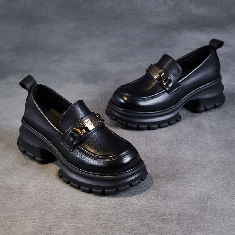 "Mocassins femme en cuir véritable noir avec semelle plateforme et chaîne métallique, élégants et modernes."