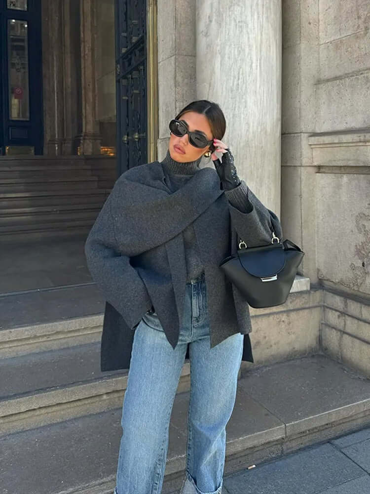"Manteau cape femme chic automne, design asymétrique gris, tissu doux, style moderne et confortable pour temps frais."