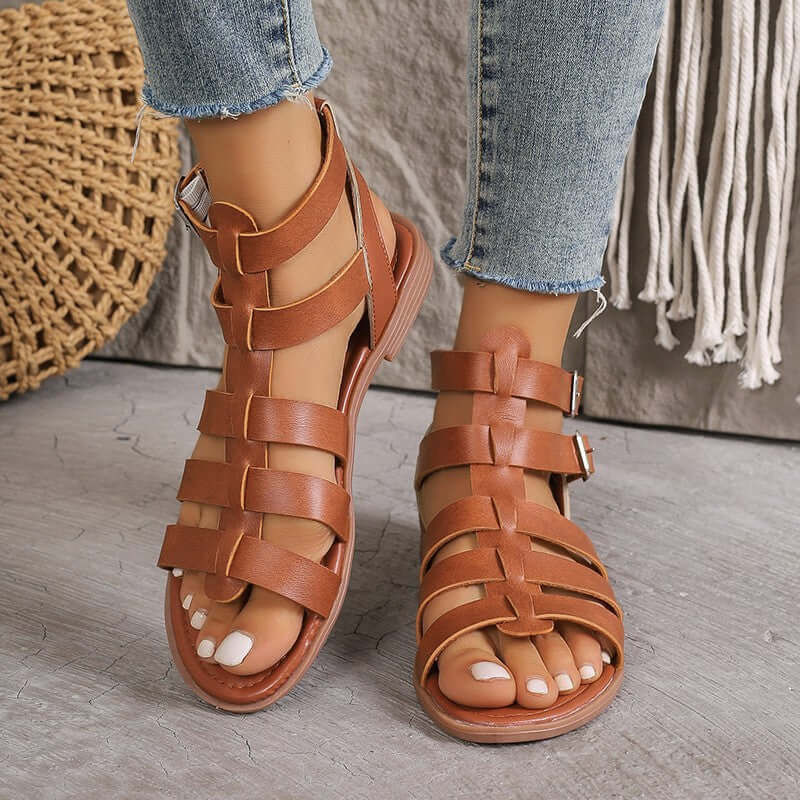 Sandales plates femme en similicuir beige style romain avec boucles réglables et bout ouvert, vue de face.