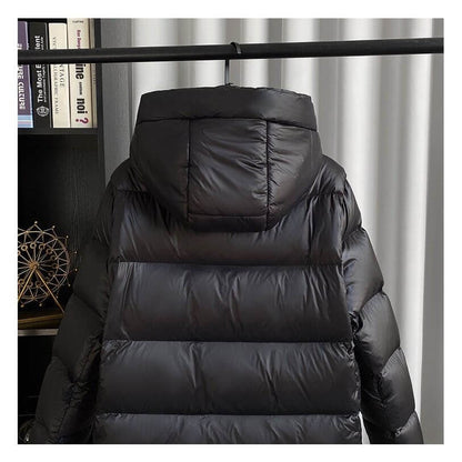 "Veste d'hiver femme en duvet, imperméable, coupe moderne, couleur neutre, idéale pour le froid avec capuche amovible."