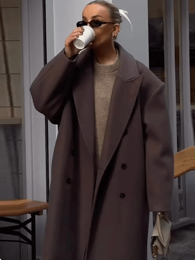 "Manteau long classique femme hiver élégant avec col imposant, coupe ajustée, couleur neutre, idéal saisons froides."