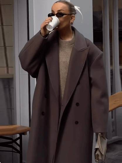 "Manteau long classique femme hiver élégant avec col imposant, coupe ajustée, couleur neutre, idéal saisons froides."