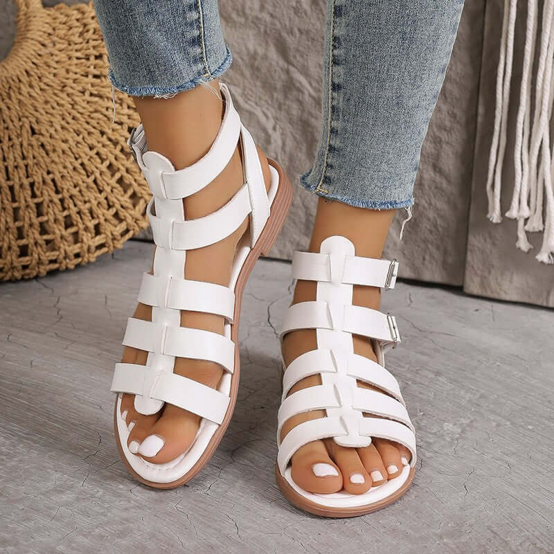 Sandales plates femme en similicuir beige style romain avec boucles réglables et bout ouvert, vue de face.