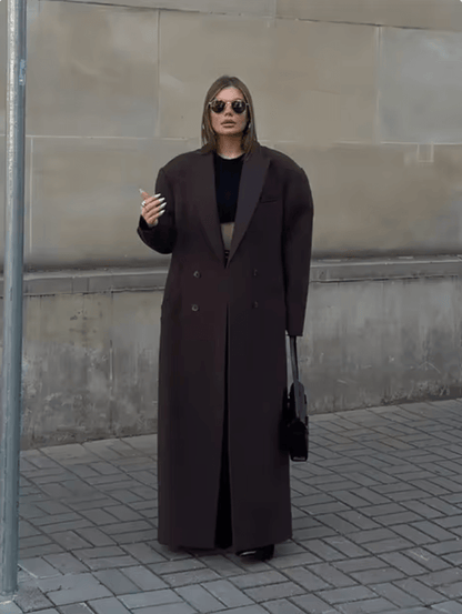 "Manteau long classique femme hiver élégant avec col imposant, coupe ajustée, couleur neutre, idéal saisons froides."