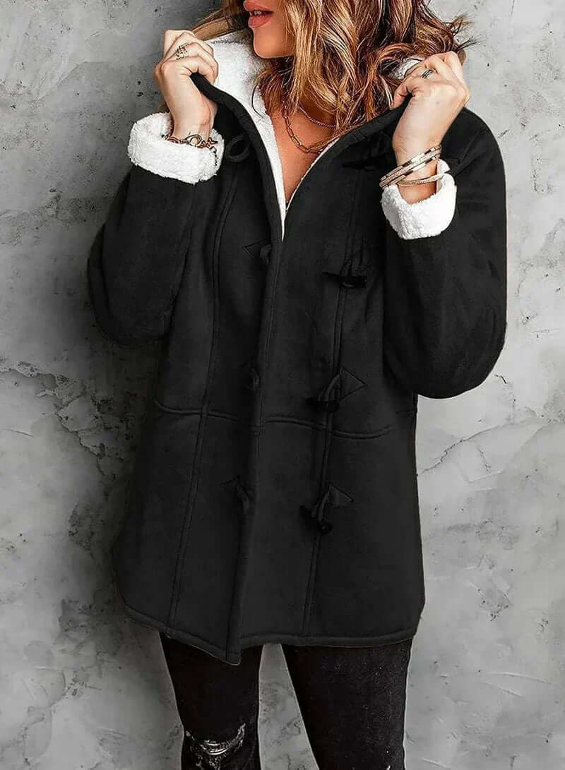 Manteau long en cachemire gris, coupe élégante avec capuche intégrée et boutons en corne, offrant chaleur et douceur.