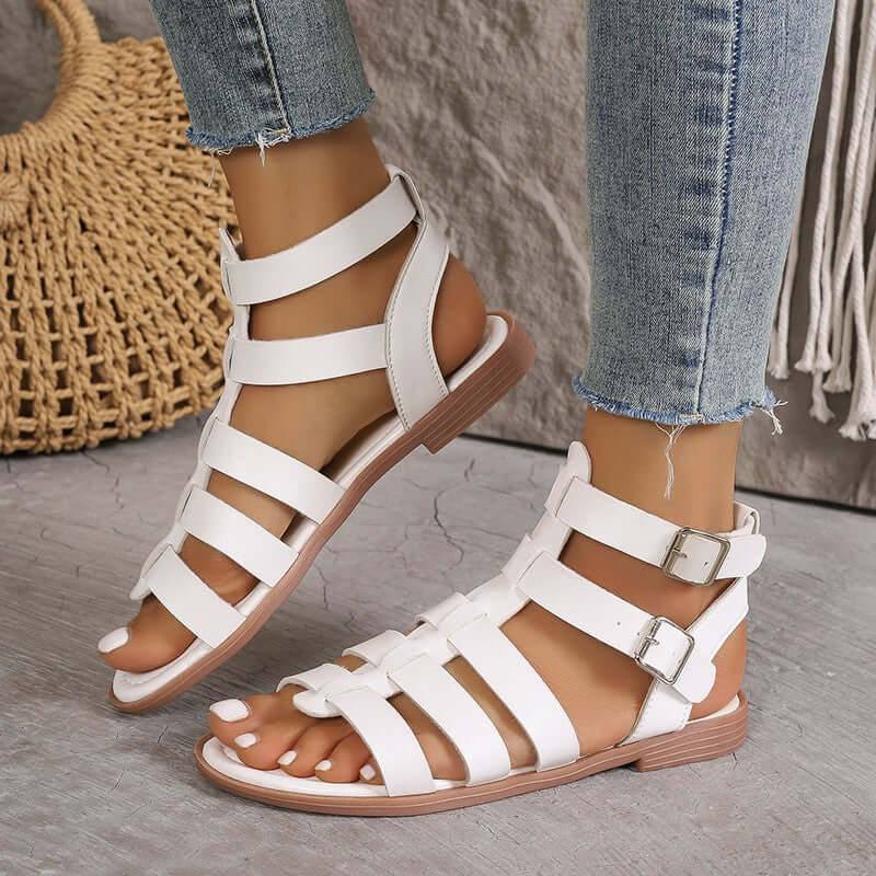 Sandales plates femme en similicuir beige style romain avec boucles réglables et bout ouvert, vue de face.