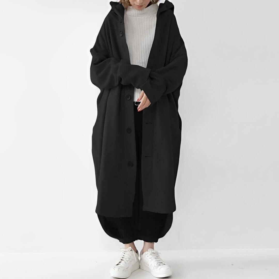 "Trench coat long femme Julina avec capuche, coupe ample et poches latérales, élégance chic pour un look décontracté."