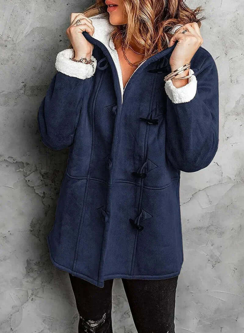 Manteau long en cachemire gris, coupe élégante avec capuche intégrée et boutons en corne, offrant chaleur et douceur.