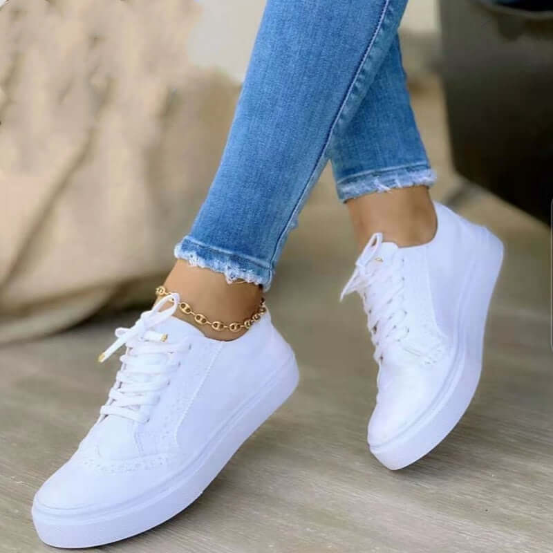 Sneakers orthopédiques élégantes pour femme en cuir blanc, avec semelle de soutien confortable et design moderne.