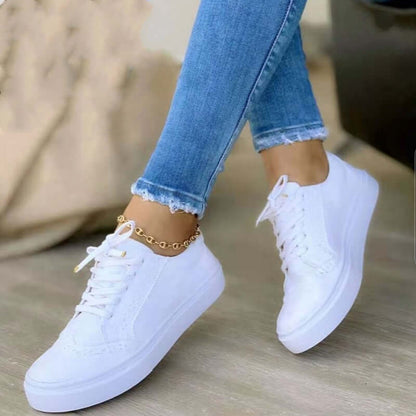Sneakers orthopédiques élégantes pour femme en cuir blanc, avec semelle de soutien confortable et design moderne.